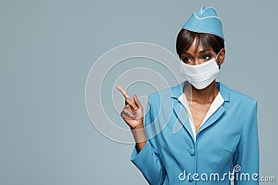 Young african stewardess wearing an antiviral mask on her face. Stock Photo