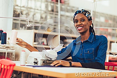 African textile worker sewing on production line Stock Photo