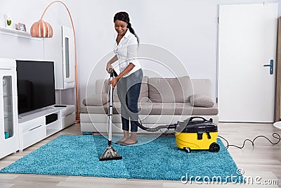 Woman Cleaning Carpet With Vacuum Cleaner Stock Photo