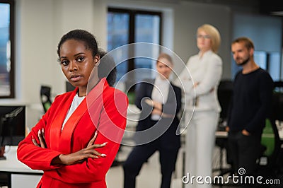 Young african woman is upset because of the ridicule of colleagues. Racial discrimination in the office. Stock Photo