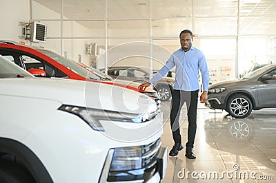 young africanamerican man came to see automobiles in dealership or cars showroom Stock Photo