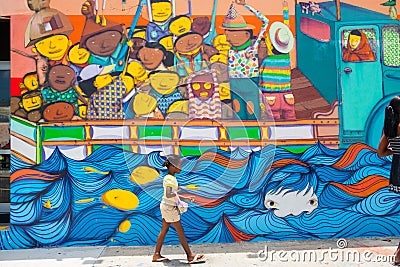 Young Afro-American girl walks by wall art image of truck loaded Editorial Stock Photo