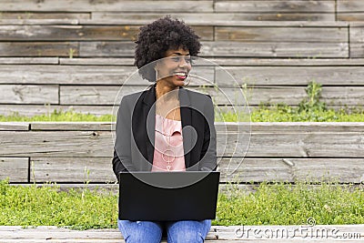 young afro American woman using laptop. Green backgrounds. Casual clothing. Lifestyles. Business.Millennial. Stock Photo