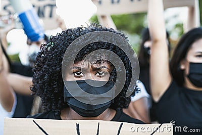 Young Afro woman activist protesting against racism and fighting for equality - Black lives matter demonstration on street Stock Photo
