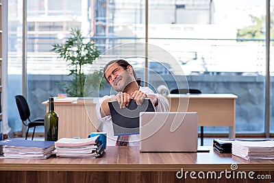 Young male alcohol addicted employee working in the office Stock Photo