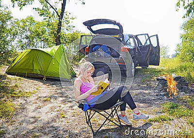 Young alluring blonde woman reading book in outdoor Stock Photo