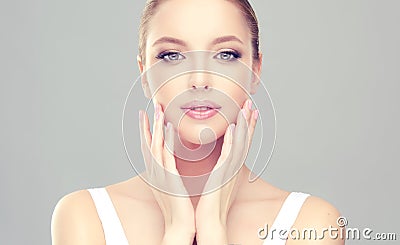 Alluring woman with clean fresh skin is touching the face tenderly. Stock Photo