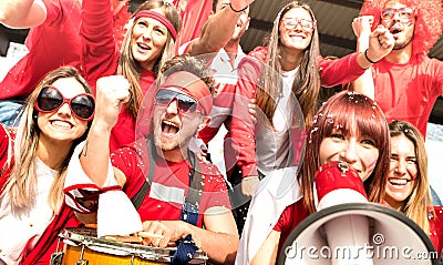 Young amateur football supporter fans cheering with flags watching local soccer cup match at stadium - Friends people group with Stock Photo