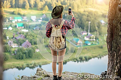 Young ambitious girl taking photo, trying to catch wonderful moment Stock Photo