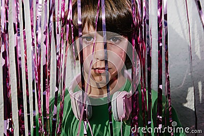 Young American boy wearing headphones near the purple confetti tapes - the concept of DJing Stock Photo