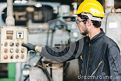Young American worker intend to work in a heavy industrial factory.control the machine press the button Stock Photo