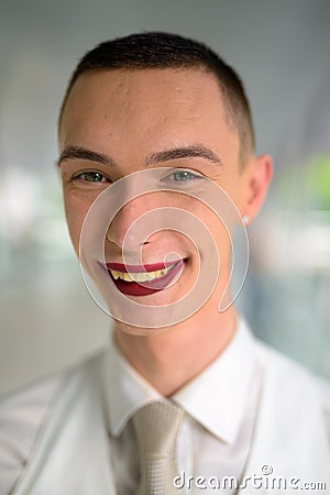 Young androgynous homosexual LGTB businessman wearing lipstick and smiling Stock Photo