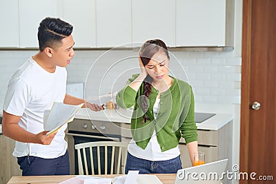 Young anxious couple quarrels by consulting their bank account Stock Photo