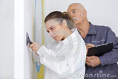 young apprentice with professional plasterer Stock Photo