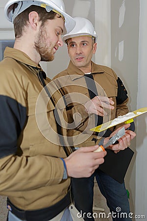 young apprentice with professional plasterer Stock Photo