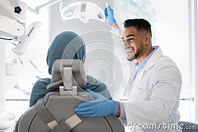 Young Arab Dentist Doctor Having Check Up With Islamic Female Patient Stock Photo