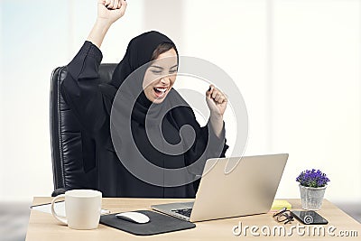 Young Arabian businesswoman expressing success at office Stock Photo