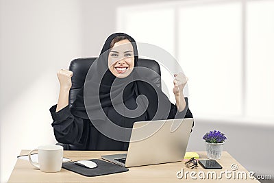 Young Arabian businesswoman expressing success at office Stock Photo