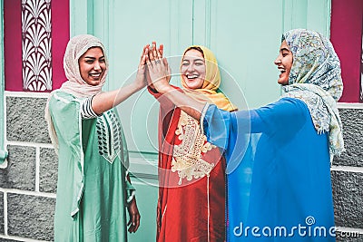 Young arabian girls stacking hands outdoor - Islamic happy women celebrating together - Youth lifestyle, university, relationship Stock Photo