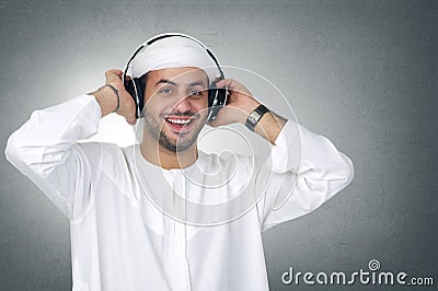 Young Arabian man listening to music using headphones Stock Photo