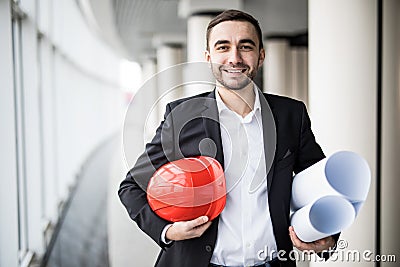 Young architect holding print and hamlet in office , engineering and contractor concept Stock Photo