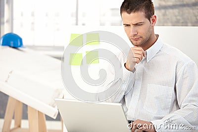 Young architect working on laptop Stock Photo