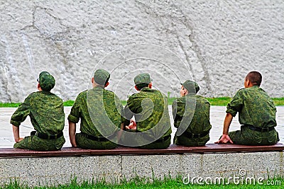 Young army men sitting on a bench Editorial Stock Photo