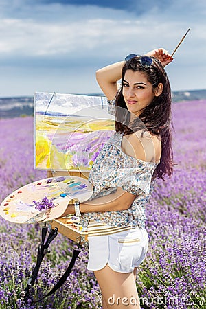 Young artist painting in lavender field Stock Photo