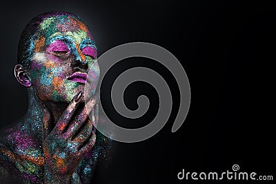 Young artistic woman in black paint and colourful powder. Glowing dark makeup. Creative body art on the theme of space Stock Photo