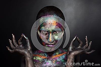 Young artistic woman in black paint and colourful powder. Glowing dark makeup. Creative body art on the theme of space Stock Photo