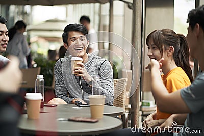 Young asian adults relaxing at outdoor coffee shop Stock Photo