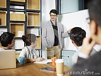 Young asian business person facilitating a discussion Stock Photo