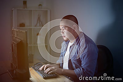 Young Asian businessman entrepreneur working overtime alone in a dark office, work hard for his ambition of success Stock Photo