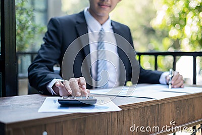 Young Asian businessman financial market analyst sits at their desks and calculate financial graphs showing the results of their Stock Photo
