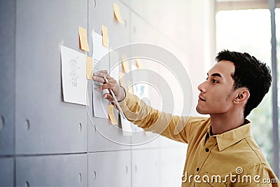Young Asian Businessman Working in Office Meeting Room. Concentrate on Document Note at the Wall. Stock Photo