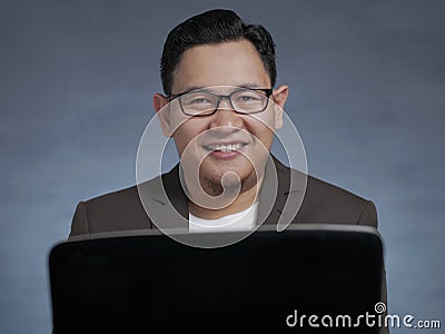 Young Businessman Working on His Laptop, Smiling Expression Stock Photo