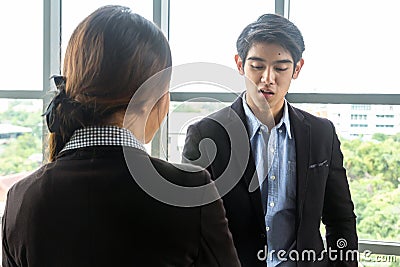 Young Asian Businessperson are standing and talking about financial business concept to agree on trade proposals within the modern Stock Photo