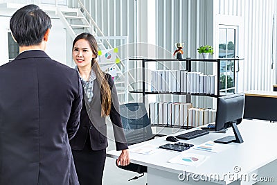 Young Asian Businessperson are standing and talking about financial business concept to agree on trade proposals within the modern Stock Photo