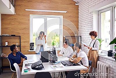 Young asian businesswoman making presentation for multi-ethnic group of listeners Stock Photo