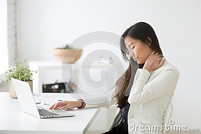 Young asian businesswoman feels neck pain after sedentary comput Stock Photo