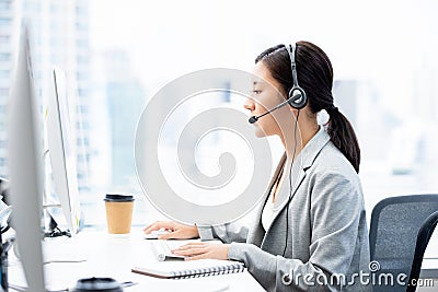 Asian businesswoman wearing headsets working in call center city office Stock Photo