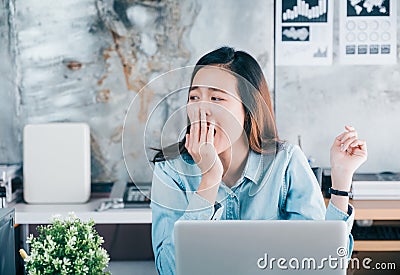 Young asian casual businesswoman yawn in front of laptop compute Stock Photo