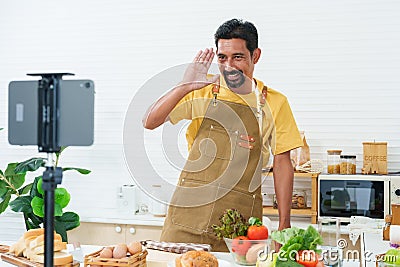 Young asian young chef who is good at cooking, love cook, standing live via online app in kitchen, was standing there talking Stock Photo