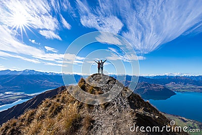 Young Asian couple celebrating success at Roys Peak Lake Wanaka New Zealand Editorial Stock Photo