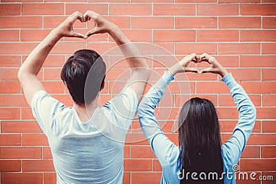 Young asian couple happy in love with gesture hand heart shape. Stock Photo