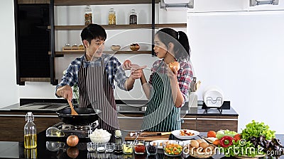 Young Asian couple are happy to cook together, two families are helping each other prepare to cook in the kitchen Stock Photo