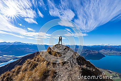 Young Asian couple holding hands kissing at Roys Peak Lake Wanaka New Zealand Editorial Stock Photo