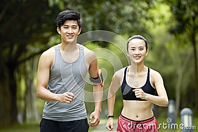 Young asian couple running jogging in a park Stock Photo