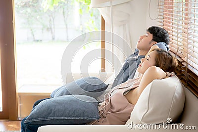 Young asian couple smile relax comfortable on sofa in the living room in holiday, family leisure and resting with happy Stock Photo