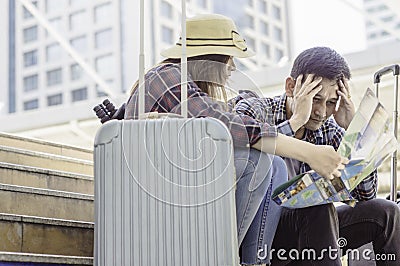 Young Asian Couple of travelers, Look at map and stress because Stock Photo